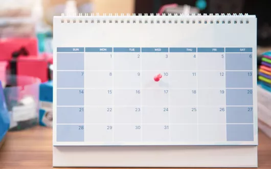 Kalendarz z przypiętą czerwoną pinezką