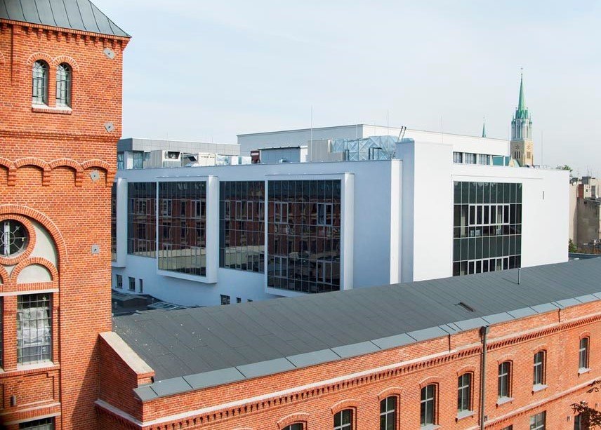 Instytut Fizyki: pofabryczny budynek z czerwonej cegły z wieżyczką. W tle biały nowoczesny budynek