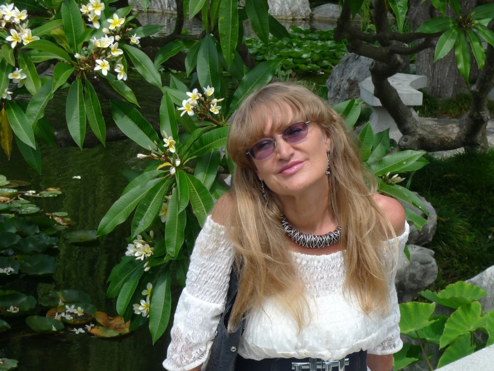 Zdjęcie portretowe: prof. Urszula Ledzewicz w białej bluzce na tle zieleni.